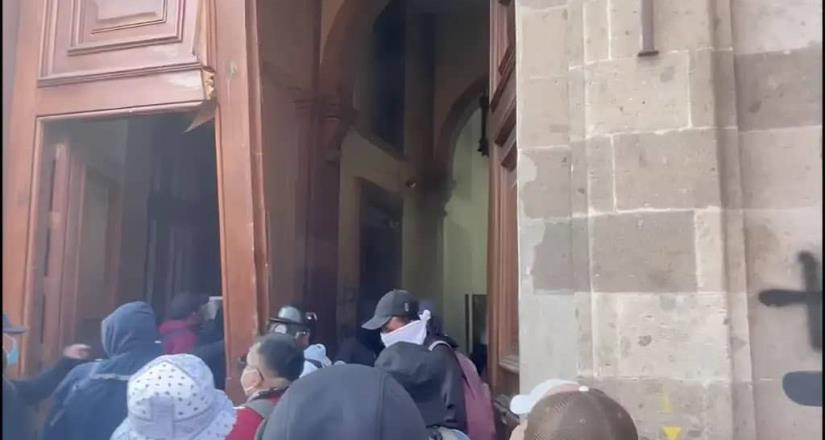 Normalistas de Ayotzinapa derriban las puertas del Palacio Nacional